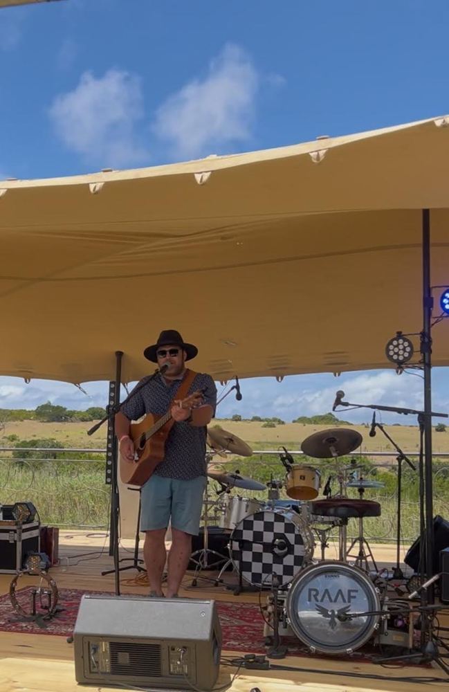 Jakoos Scheepers playing guitar and singing on stage at the Rosebarn wine festival