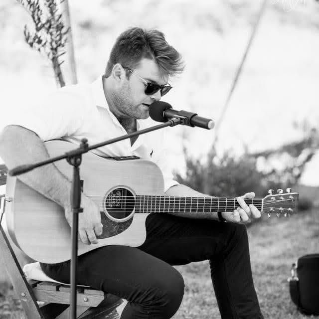 Jakoos Scheepers playing acoustic guitar and singing at a wedding
