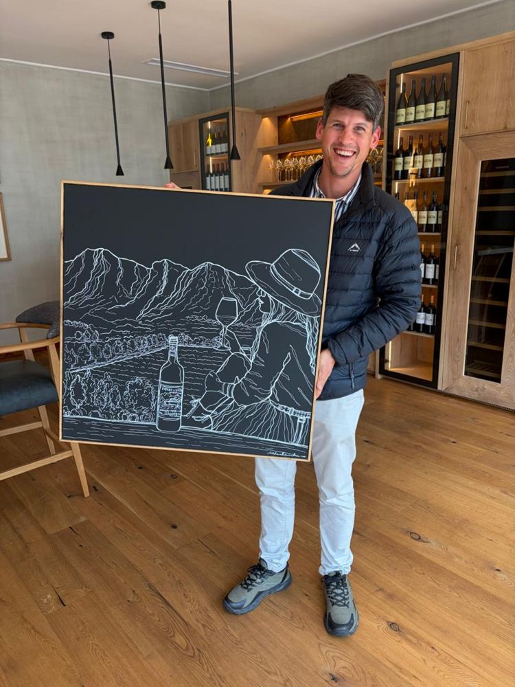 The Rupert and Rothschild winemaker holding the finished painting