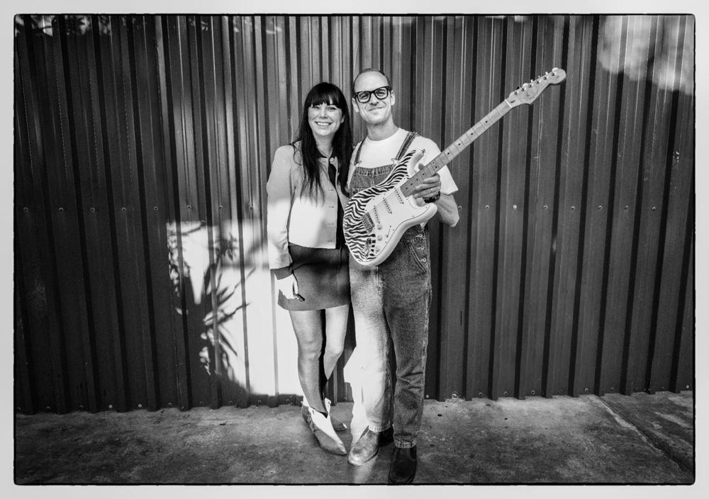 Hilde with Danie du Toit of Spoegwolf, holding his hand-drawn zebra guitar